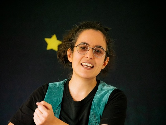 Photo de la conteuse en train de chanter un refrain à reprendre avec le public